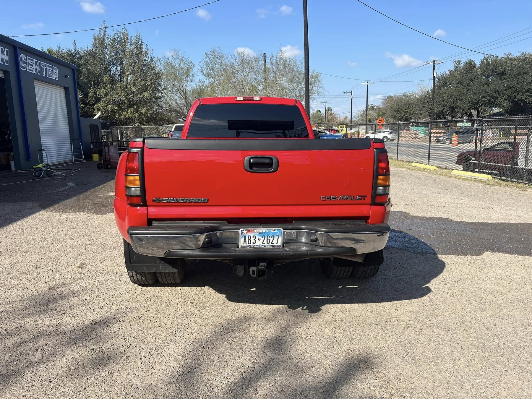 Red Chevrolet Silverado with repaired tailgate, bumper, and rear bodywork