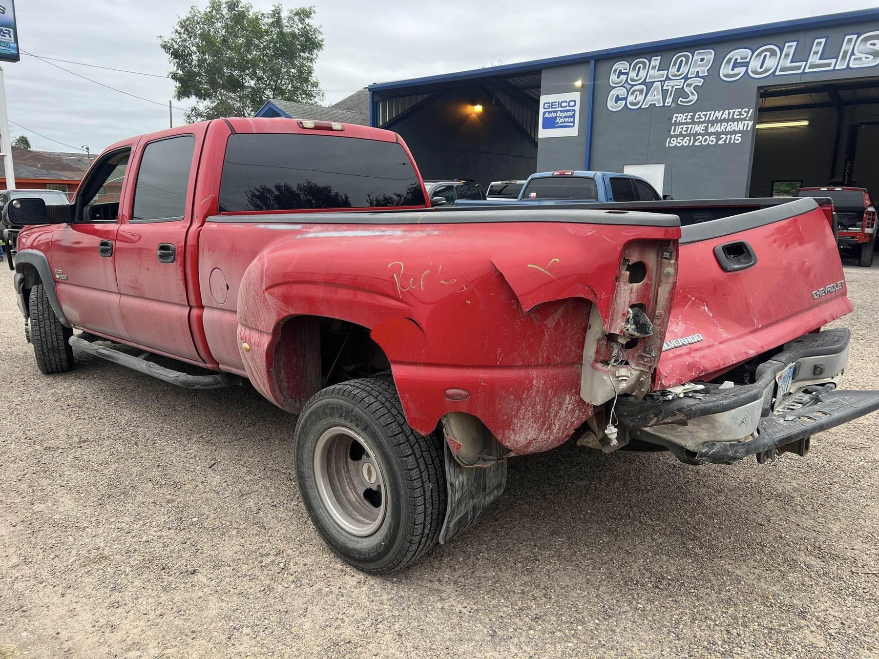 Red Chevrolet Silverado with extensive rear driver-side collision damage before repair