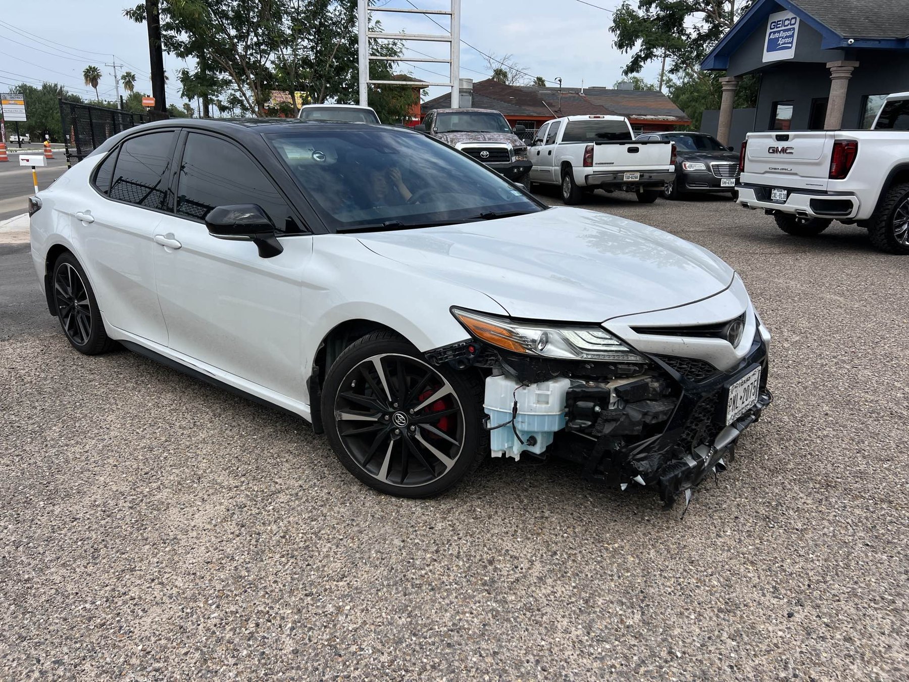 White Toyota Camry with front passenger-side collision damage before repair
